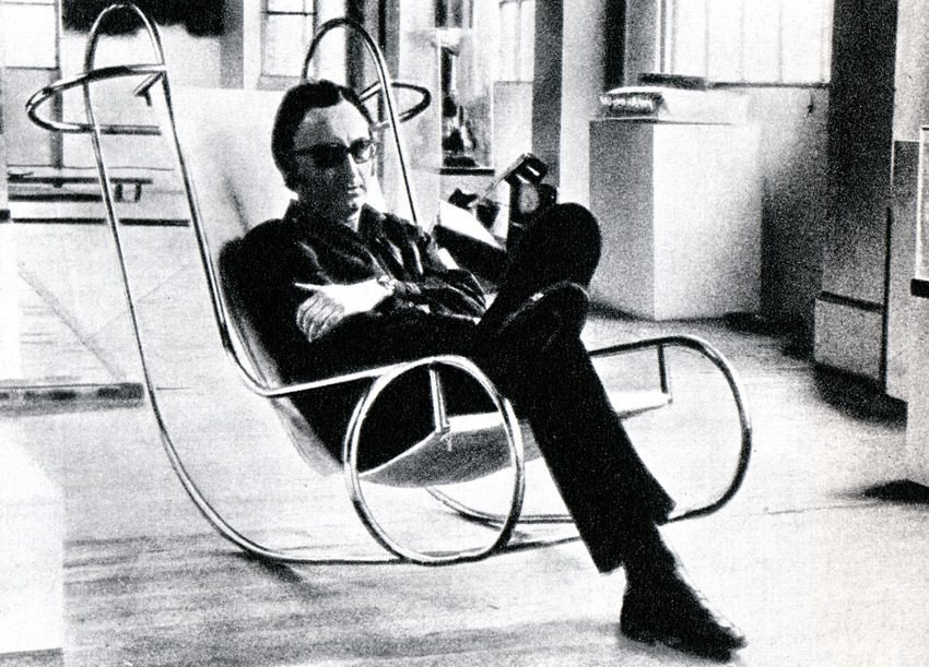 Jean-Michel Sanejouand assis dans le modèle de test de son fauteuil à bascule « Symétrique »  1970 - Atelier A / éditions MMM